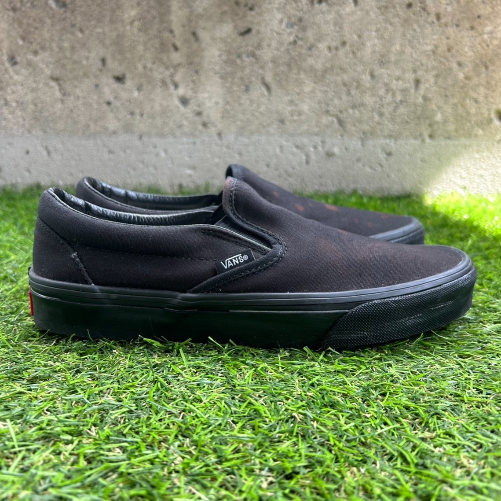 Black Vans slip-ons with bleach stains
